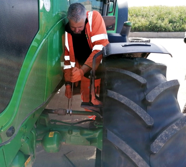 Technician adjusting the front toe setting on a John Deere tractor | Tractor Wheel Alignment | Bush Tyres